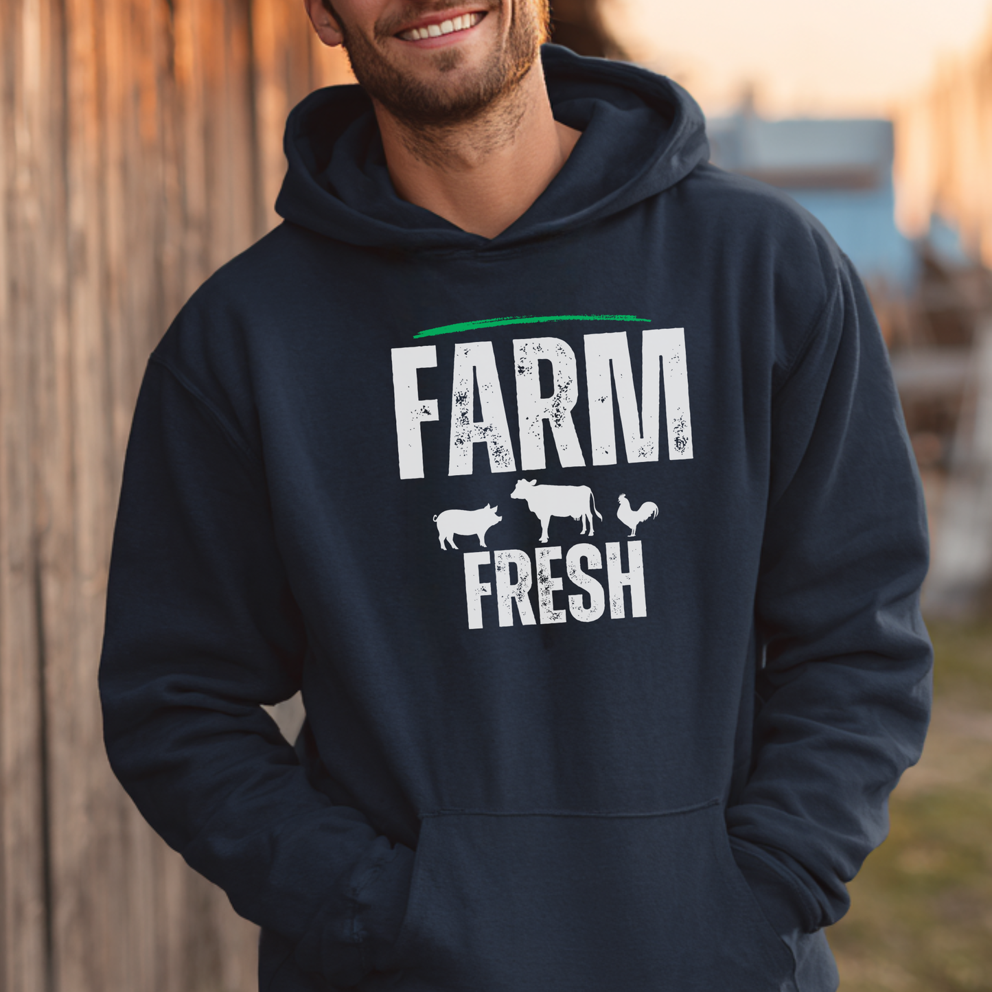 Person wearing a navy hoodie with 'Farm Fresh' text and牲畜icons outdoors.