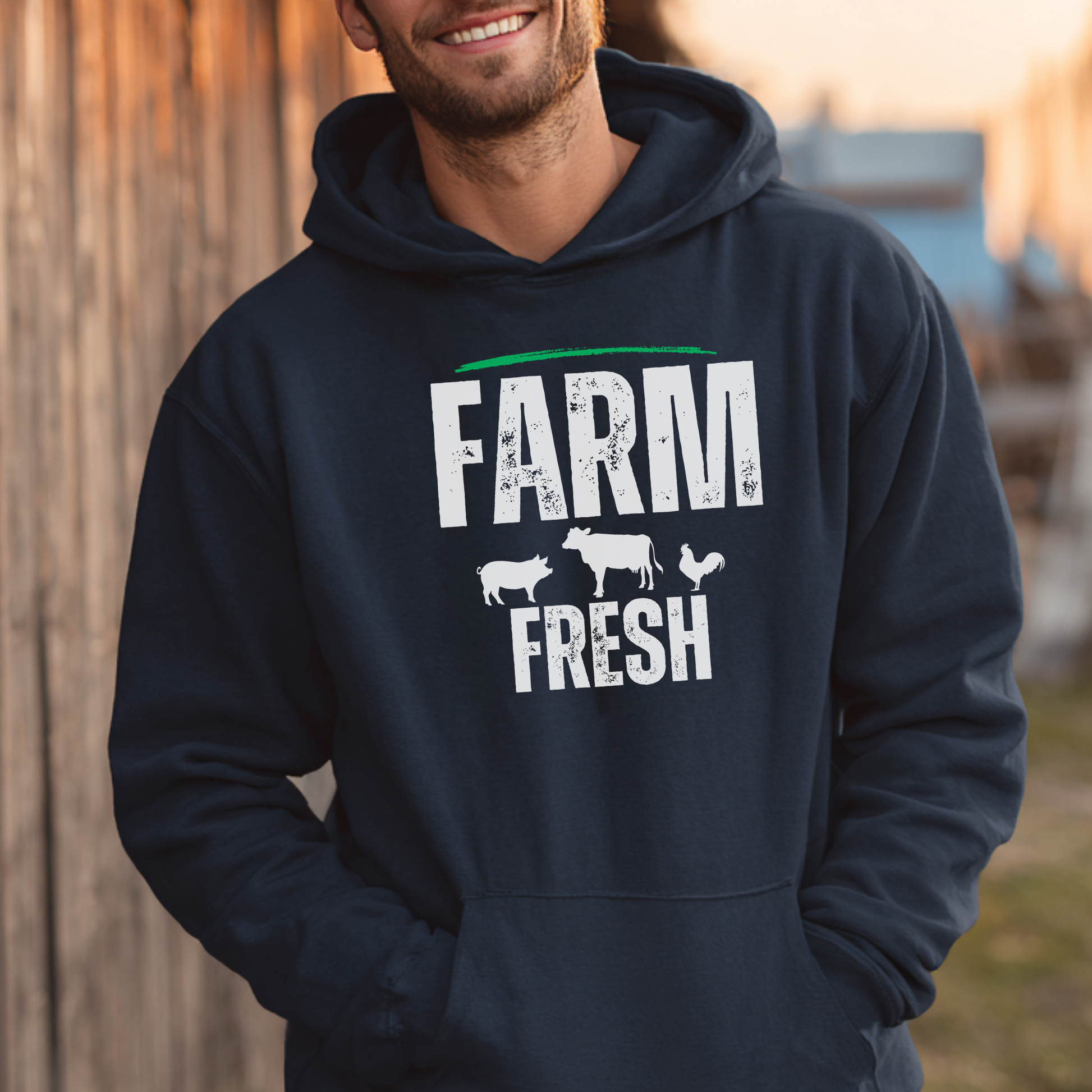 Person wearing a navy hoodie with 'Farm Fresh' text and牲畜icons outdoors.