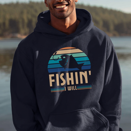 Man wearing a navy hoodie with 'FISHIN' I WILL' graphic by a lake.