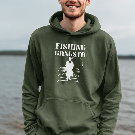 Person wearing a green hoodie with 'Fishing Gangsta' graphic by a body of water.