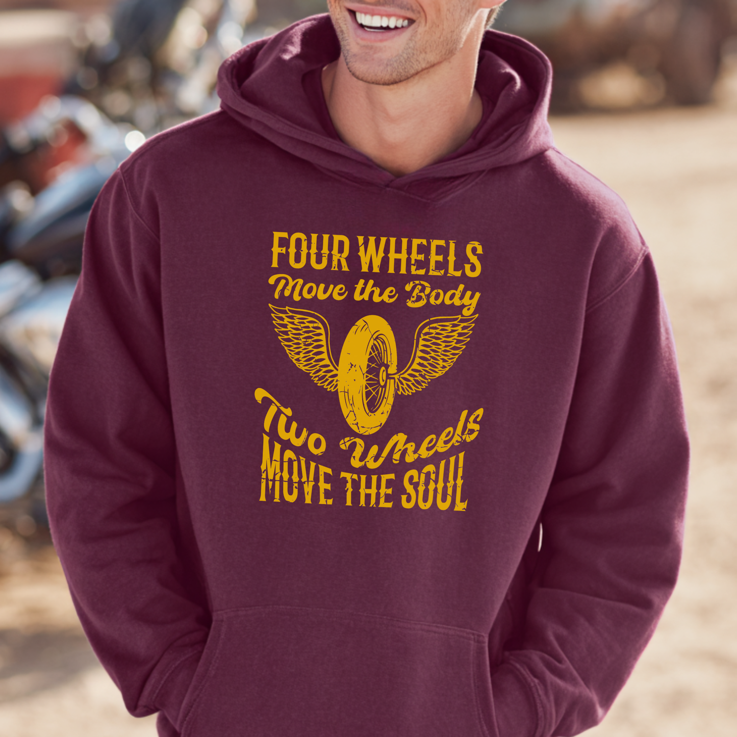 Person wearing a maroon hoodie with yellow text and graphic, standing outdoors.