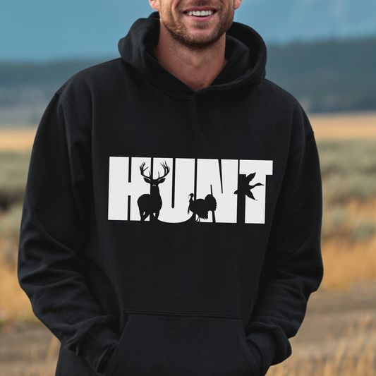Person wearing a black hoodie with 'HUNT' and animal silhouettes in a natural setting
