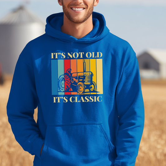 Person wearing a blue hoodie with a graphic and text in an outdoor setting