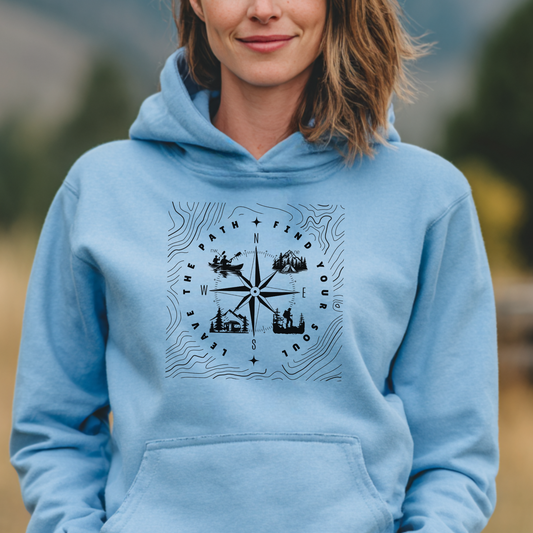 Person wearing a light blue hoodie with a compass design outdoors