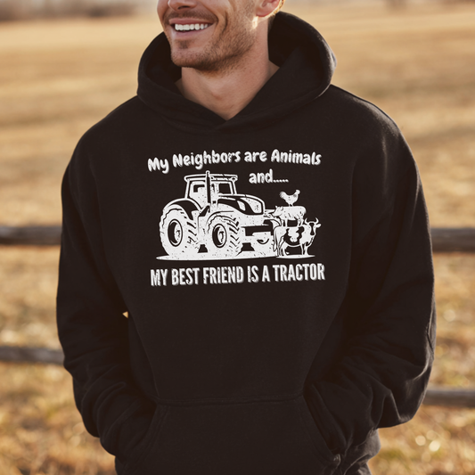 Person wearing a black hoodie with a tractor graphic and text in a field.