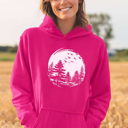 Person wearing a pink hoodie with a nature graphic in a field