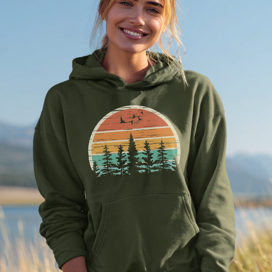 Person wearing a green hoodie with a nature graphic, standing outdoors with a scenic background.