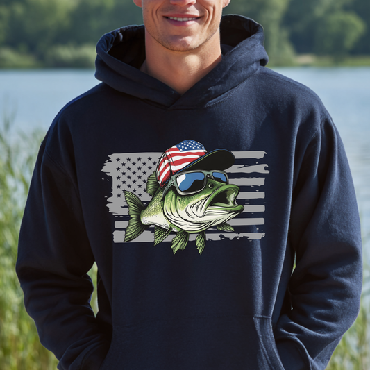 Person wearing a navy hoodie with a fish graphic and American flag design, standing outdoors by a body of water.