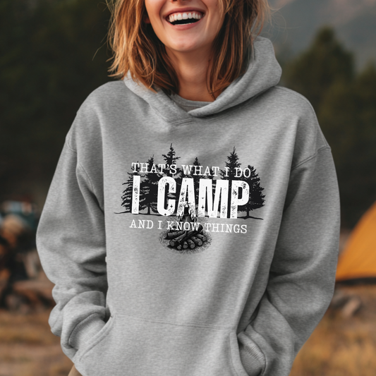 Person wearing a gray hoodie with camping-themed text and graphics, standing outdoors.