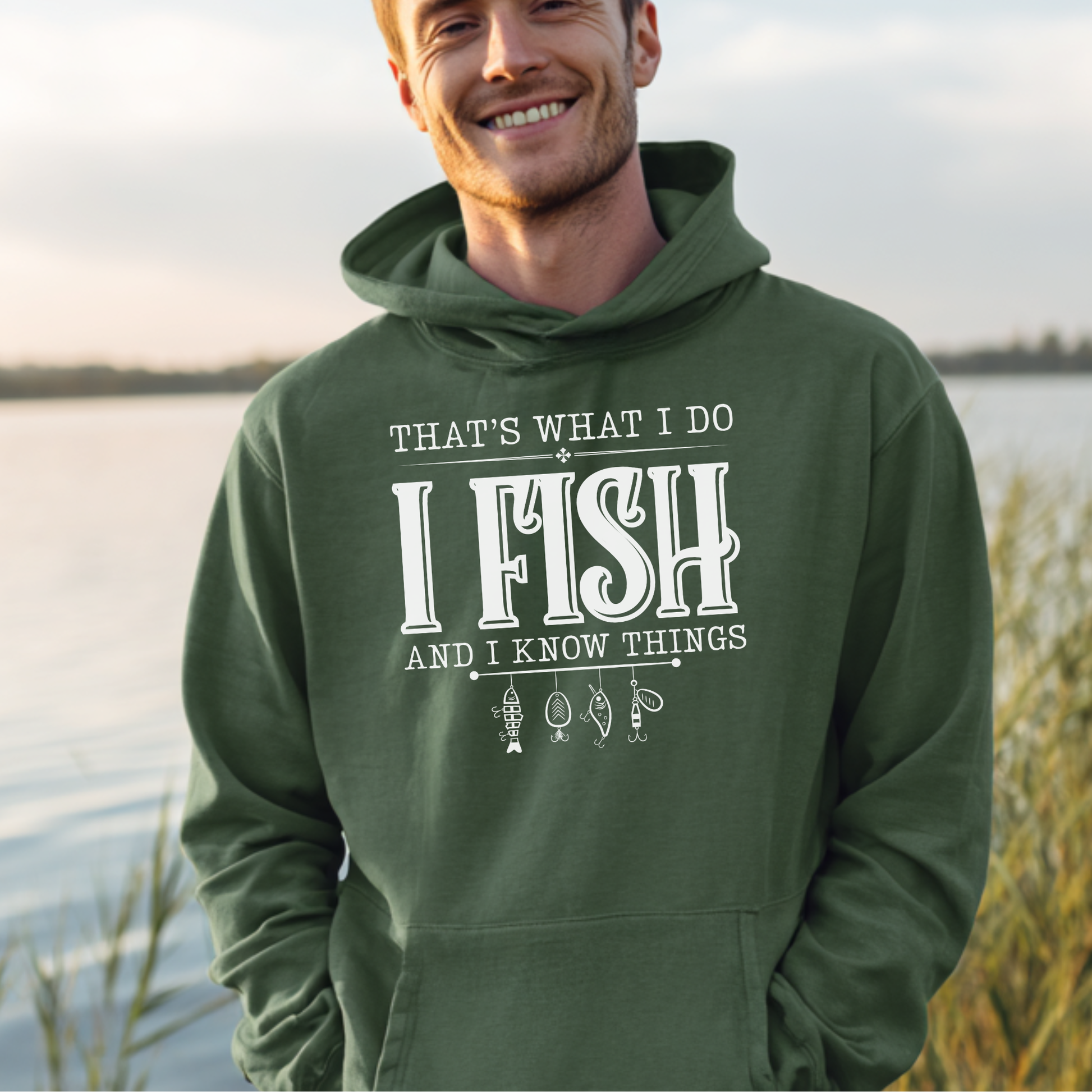 Man wearing a green hoodie with text by a lake