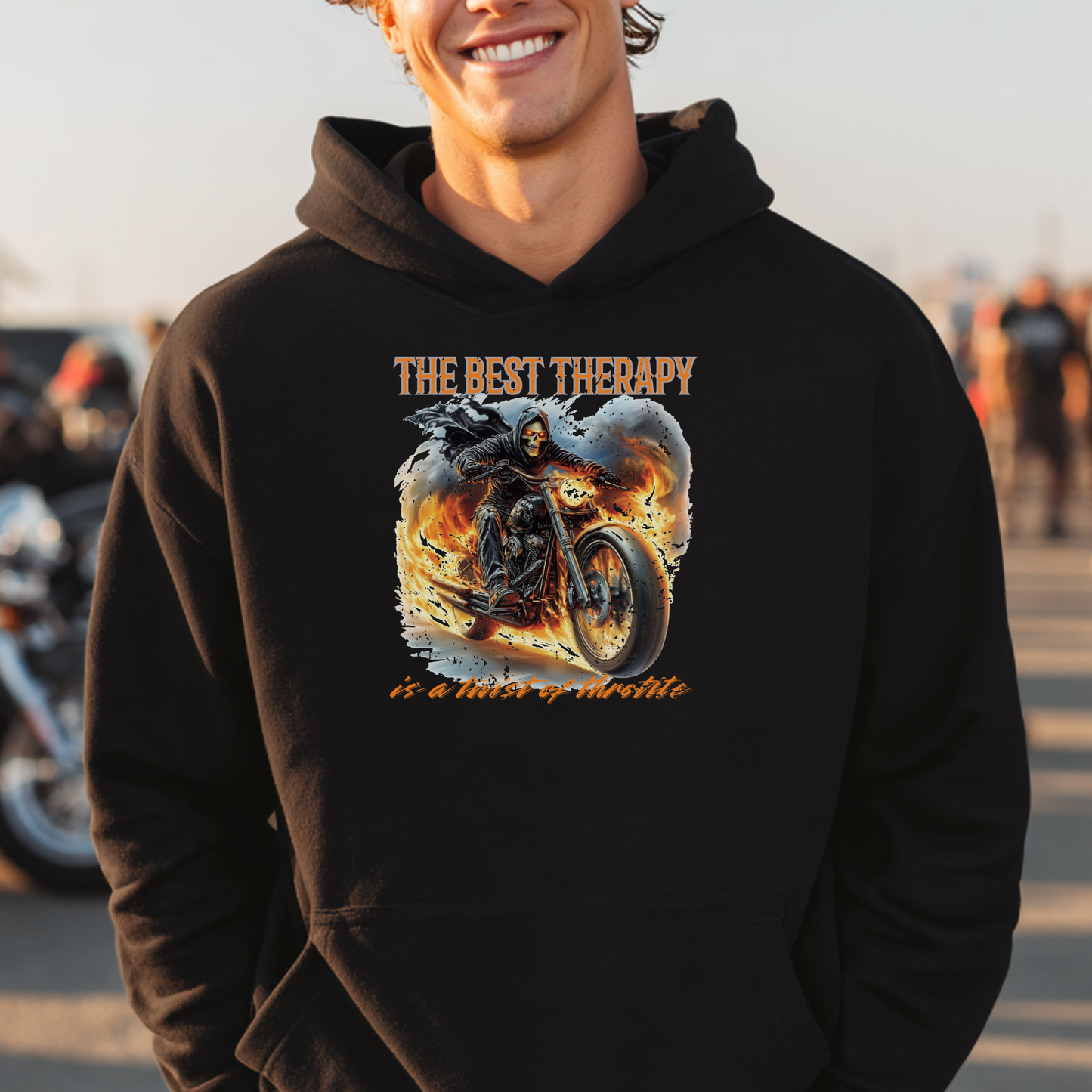 Person wearing a black hoodie with a graphic design and text, standing in an outdoor setting.