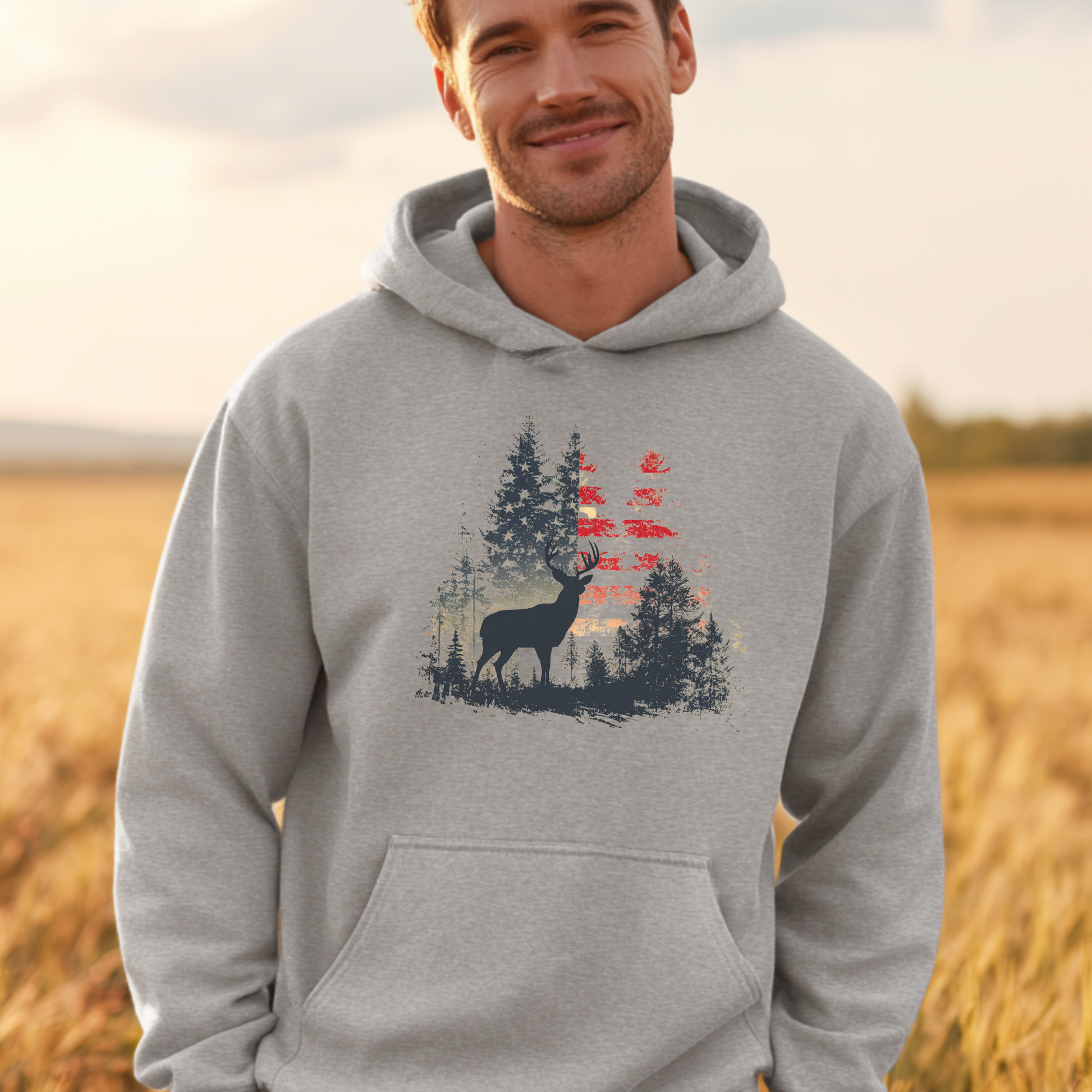 Man wearing a gray hoodie with a nature-themed design in a field