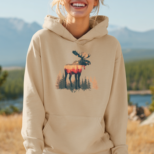 Person wearing a beige hoodie with a moose design in a scenic outdoor setting