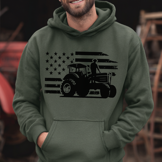 Person wearing a green hoodie with a black tractor and flag design.