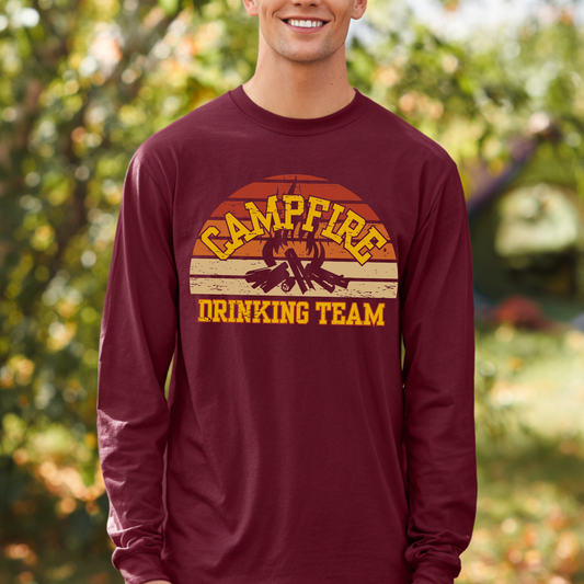 Person wearing a maroon long-sleeve shirt with 'Campfire Drinking Team' graphic outdoors.