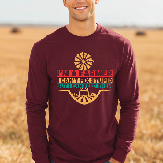 Man wearing a maroon long-sleeve shirt with a farmer-themed graphic and text in a field.