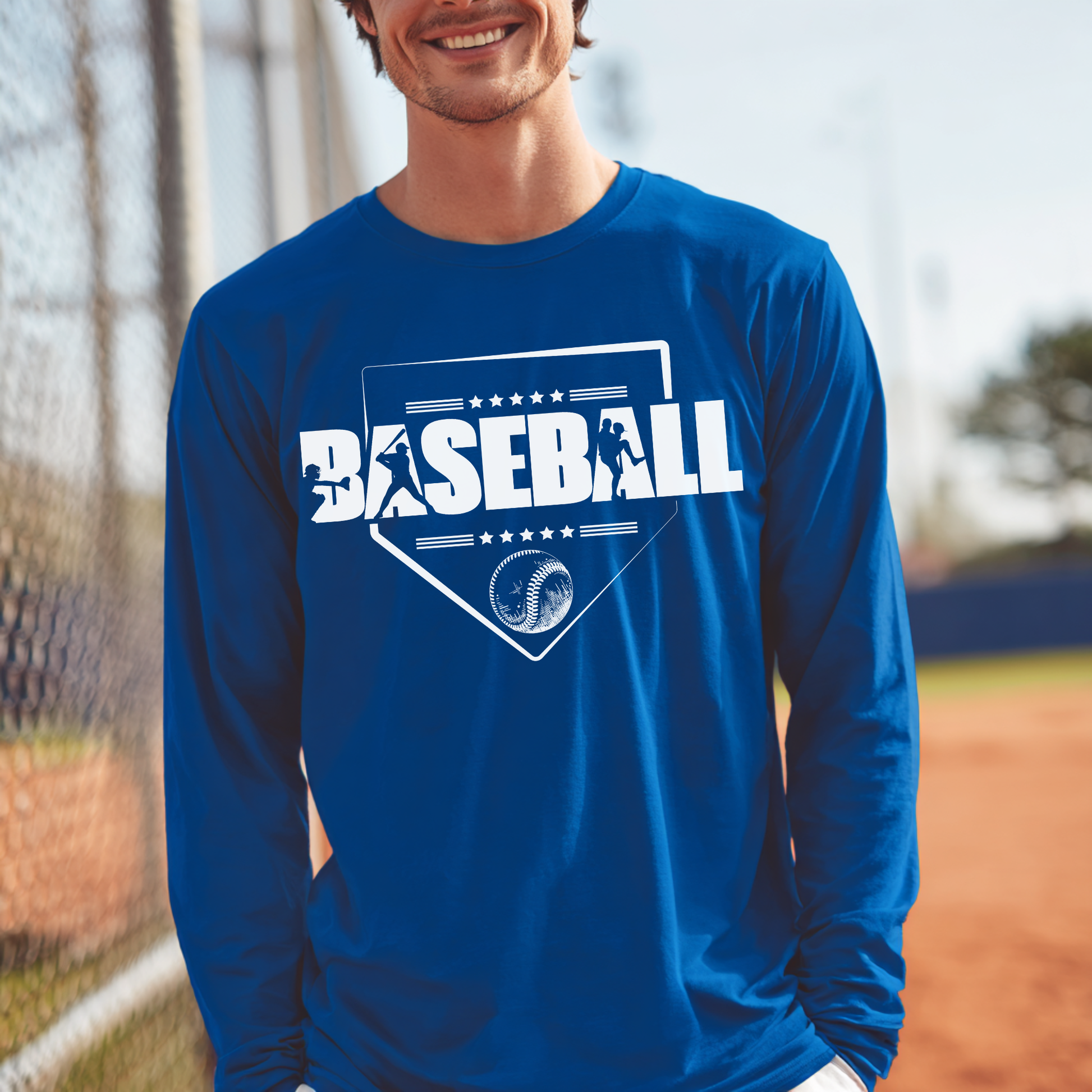Person wearing a blue long-sleeve shirt with 'BASEBALL' printed on it, standing on a baseball field.