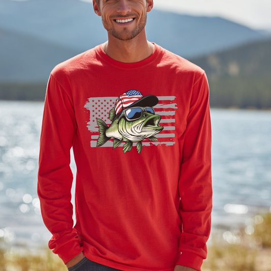 Man wearing a red long-sleeve shirt with a fish graphic and American flag design, standing by a lake.