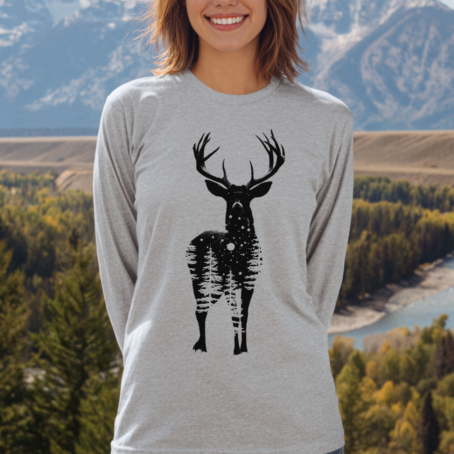 Person wearing a gray long-sleeve shirt with a black deer graphic in front of a scenic background.