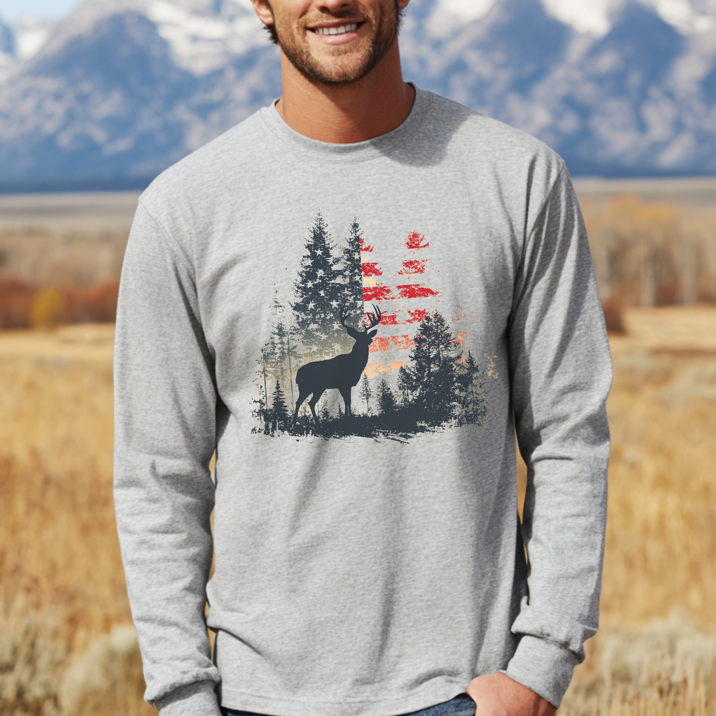 Man wearing a gray long-sleeve shirt with a nature-themed design in a scenic outdoor setting.