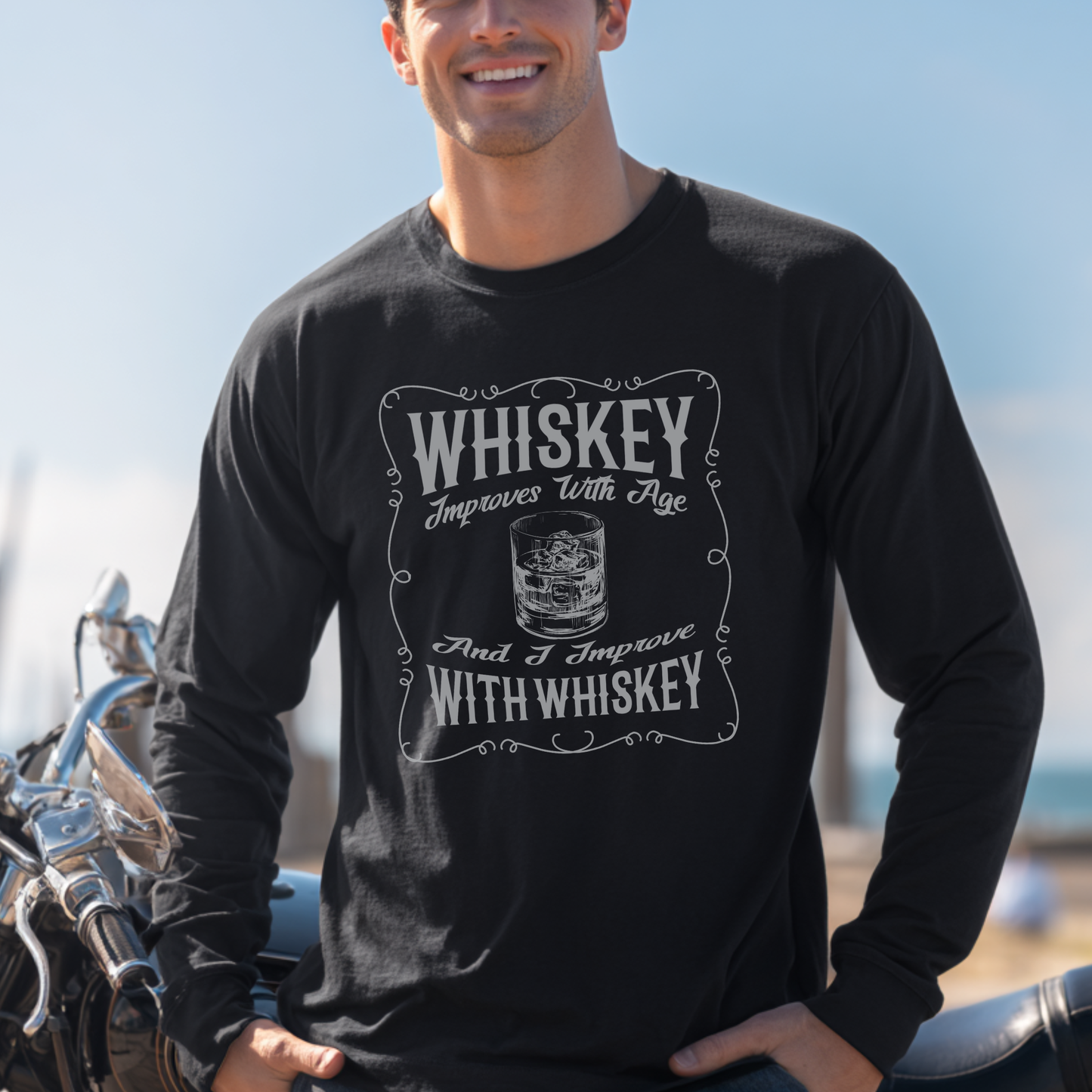 Man wearing a black long-sleeve shirt with whiskey-themed design, standing next to a motorcycle.