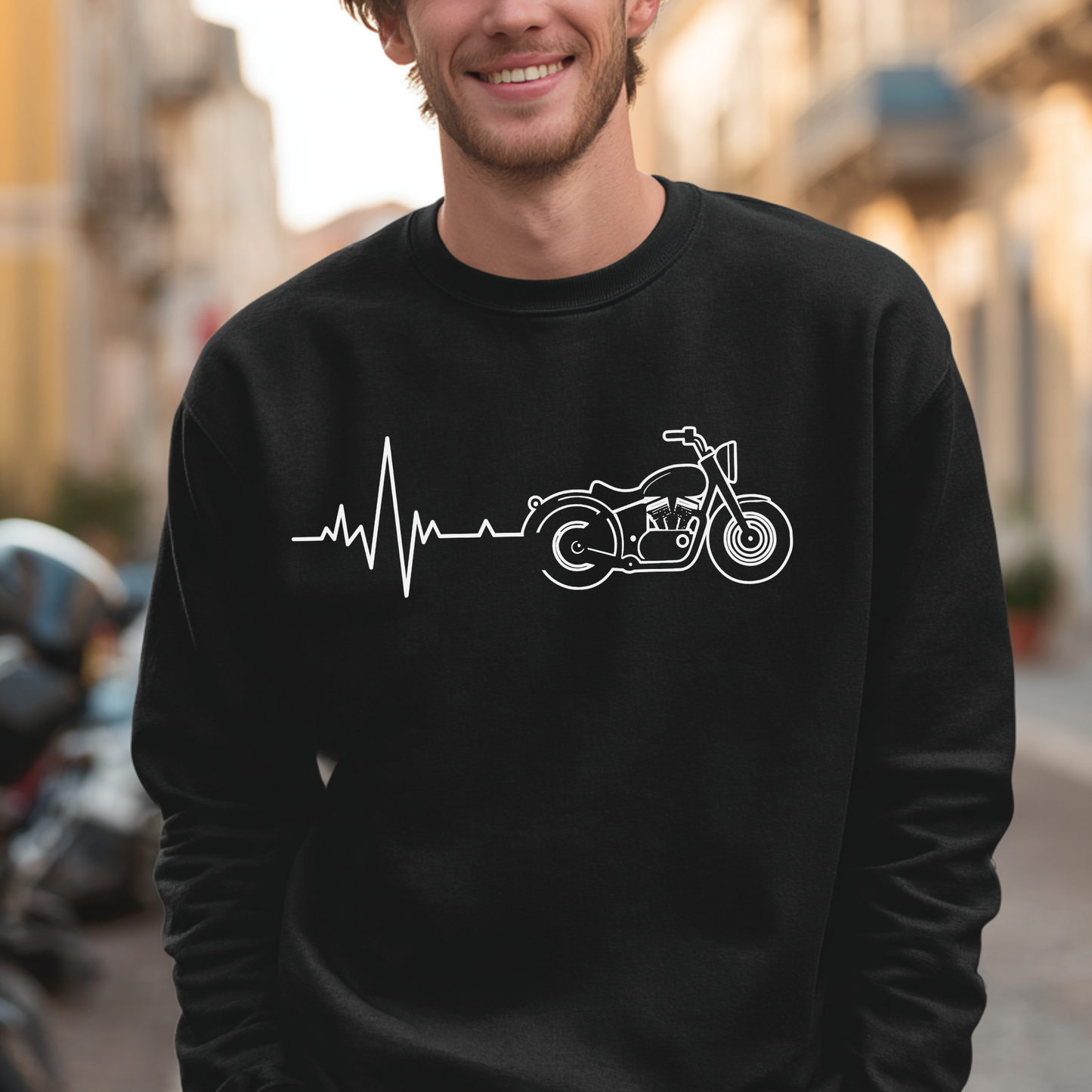 Person wearing a black sweatshirt with a white motorcycle and heartbeat line design, standing on a street.
