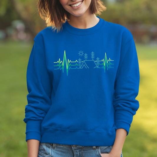 Person wearing a blue sweatshirt with a green and blue design outdoors