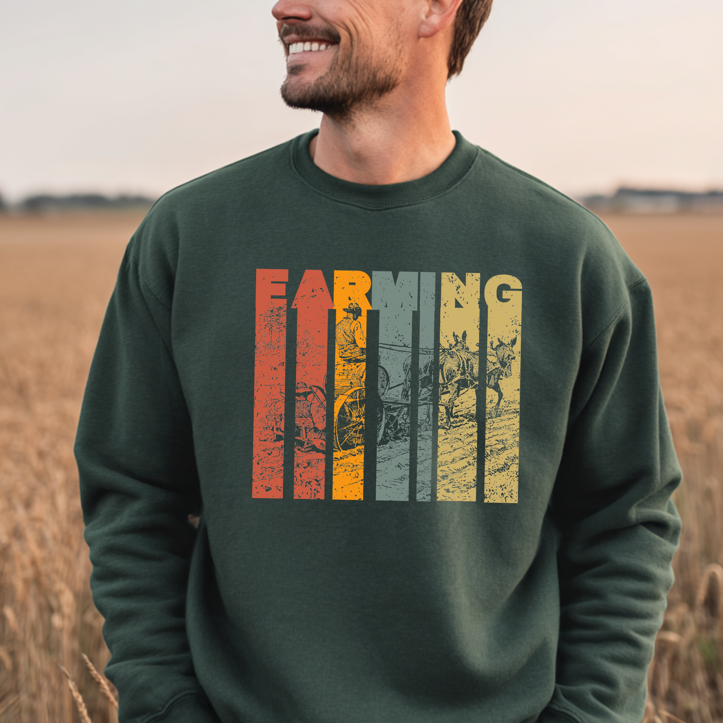 Man wearing a green sweatshirt with 'Farming' graphic in a field