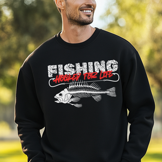 Man wearing a black sweatshirt with 'Fishing Hooked for Life' graphic outdoors.