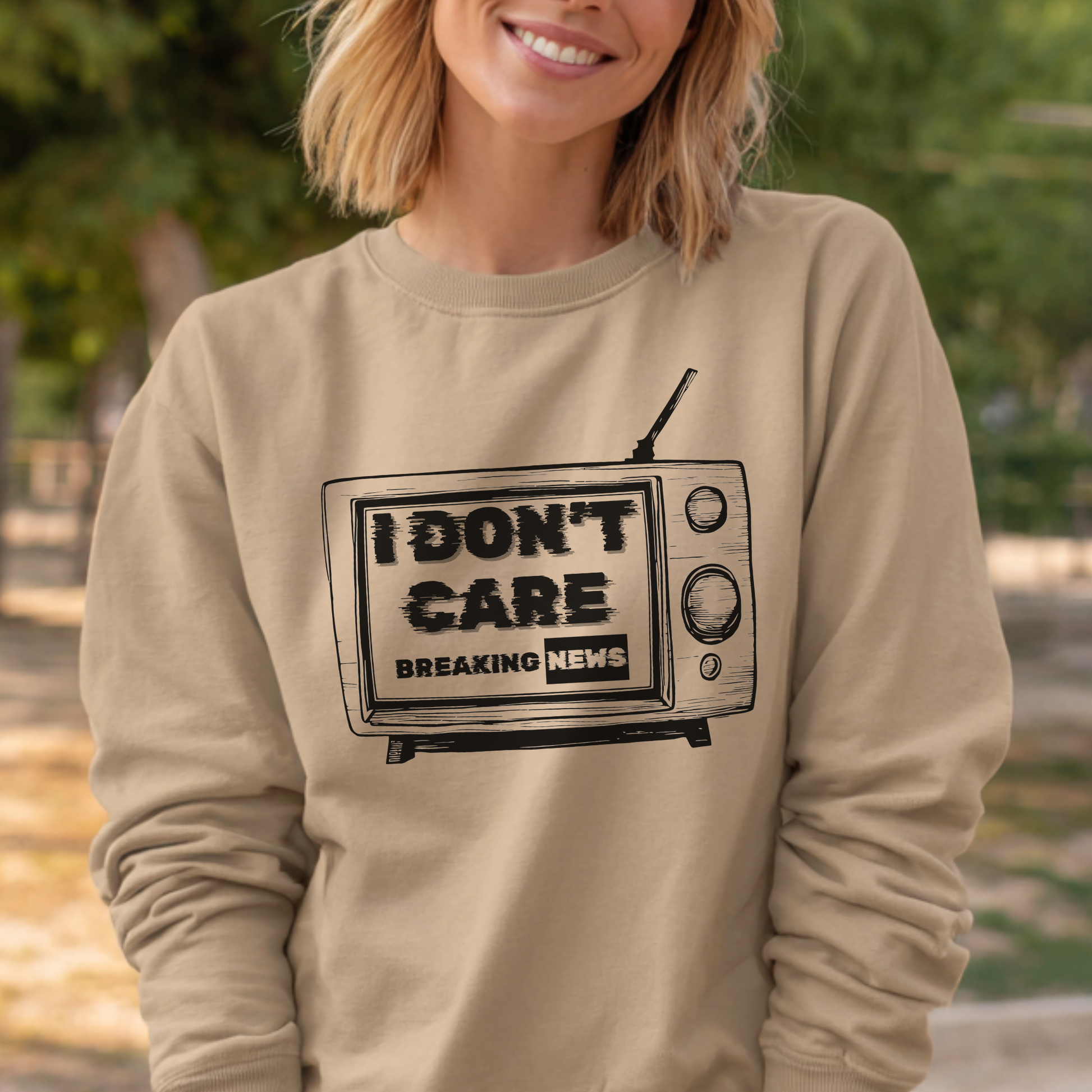 Person wearing a beige sweatshirt with a graphic of a TV and 'I Don't Care' text.