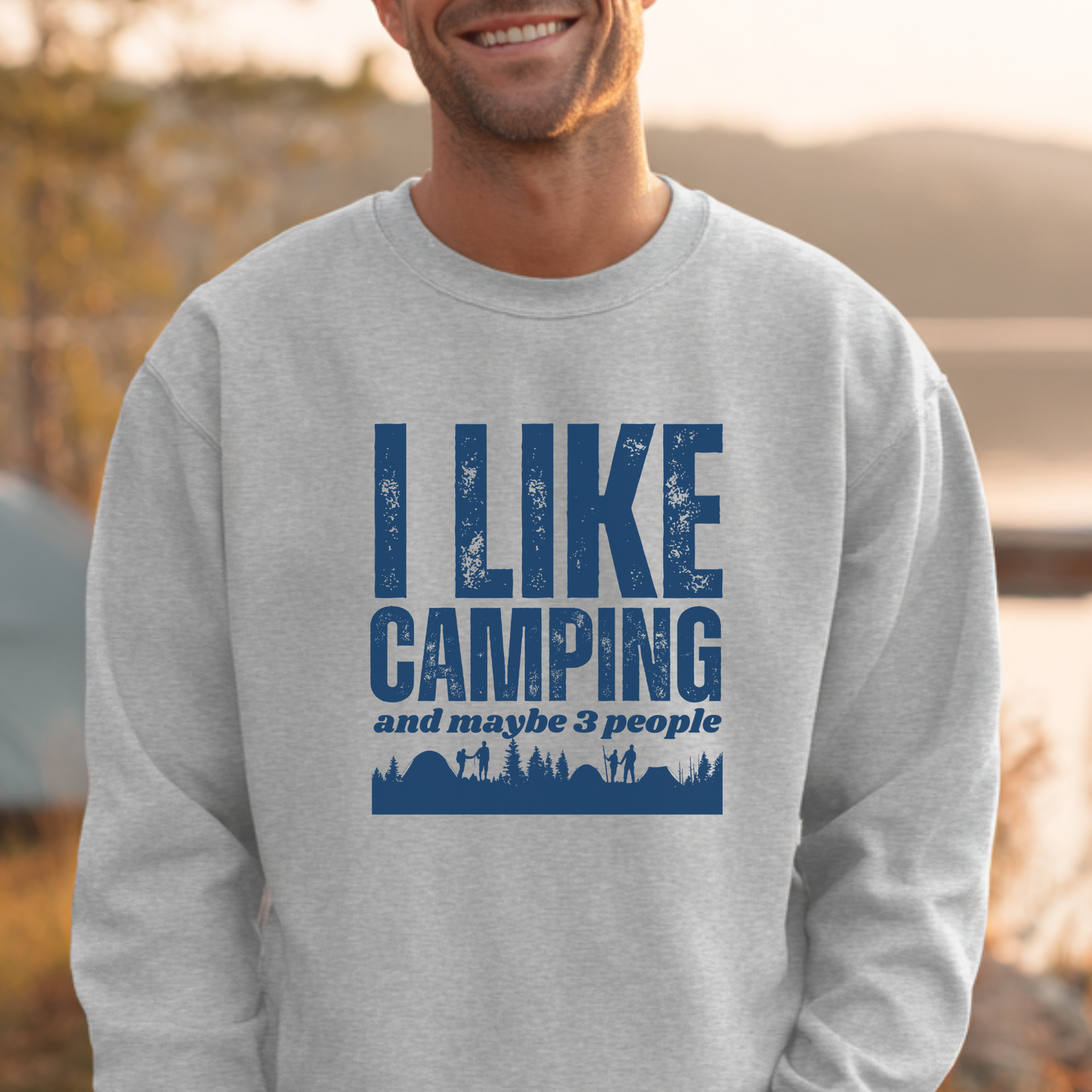Person wearing a gray sweatshirt with 'I LIKE CAMPING and maybe 3 people' text and blue graphic.