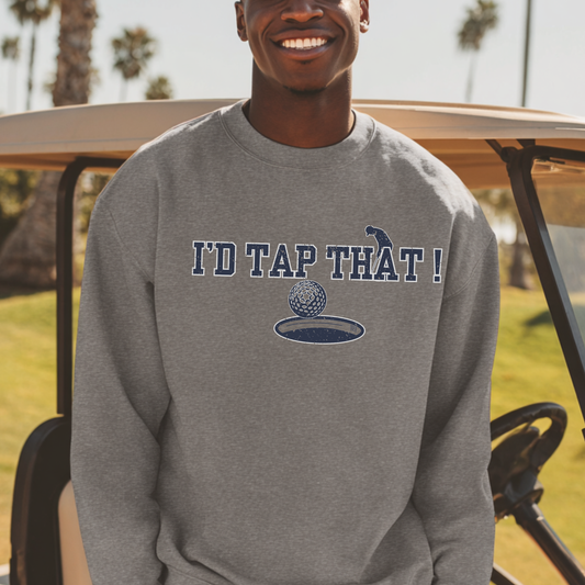 Person wearing a gray sweatshirt with 'I'd Tap That!' text and graphic, standing in front of a golf cart on a golf course.