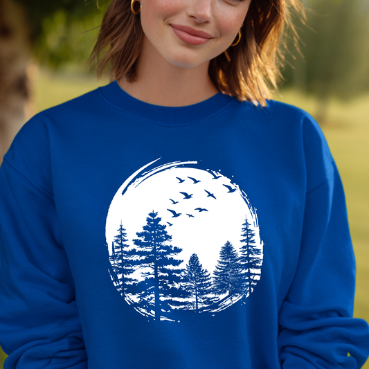 Person wearing a blue sweatshirt with a white nature graphic of trees and birds.