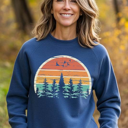 Woman wearing a blue sweatshirt with a nature-themed design outdoors.