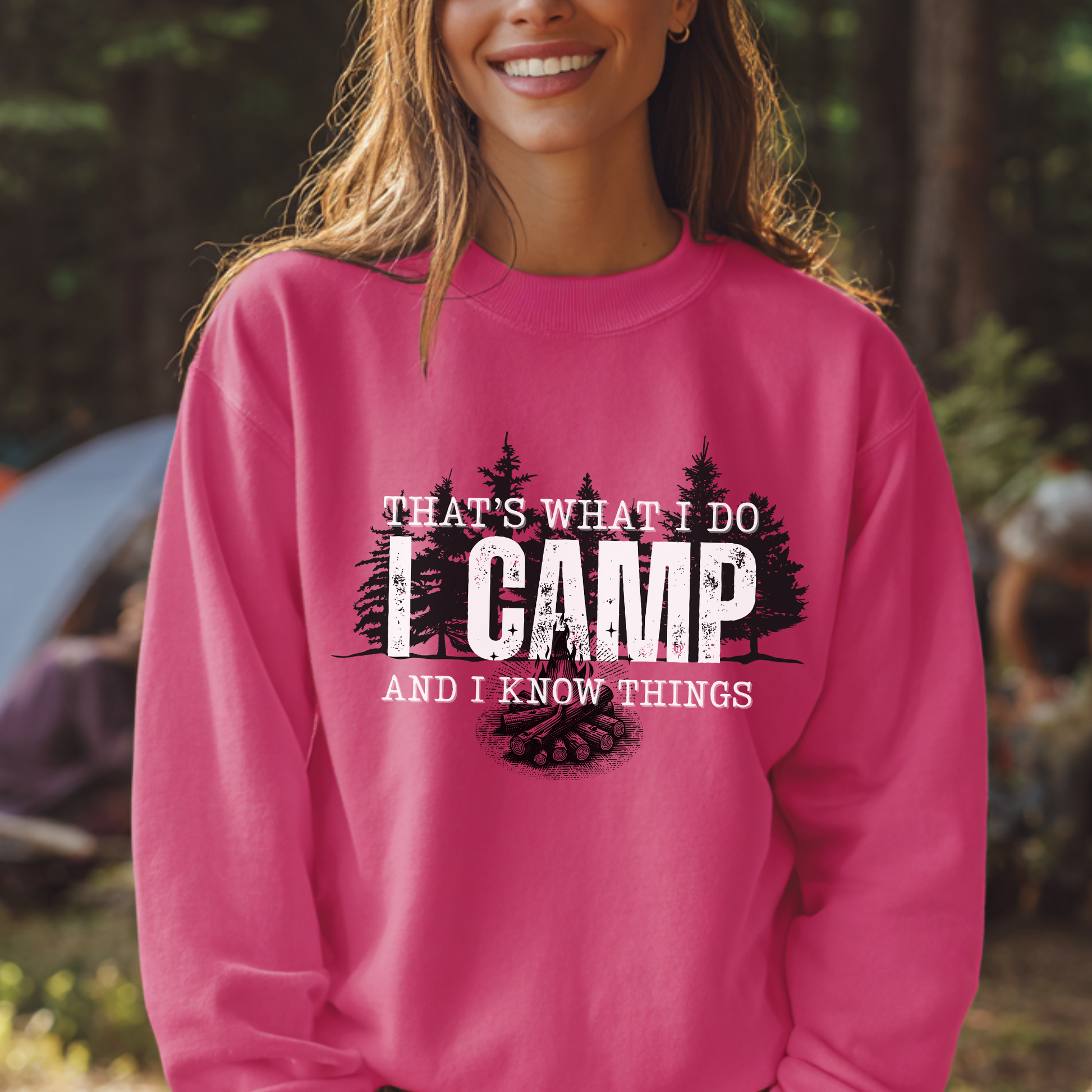 Person wearing a pink sweatshirt with camping text and graphics outdoors