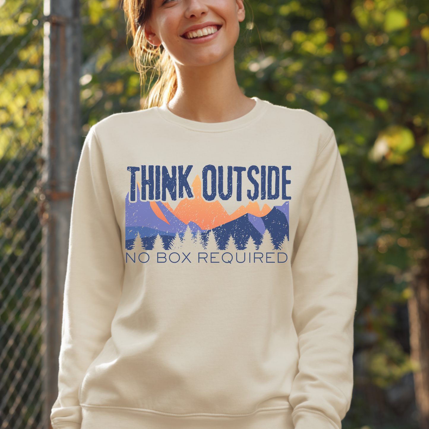 Person wearing a beige sweatshirt with 'Think Outside, No Box Required' graphic