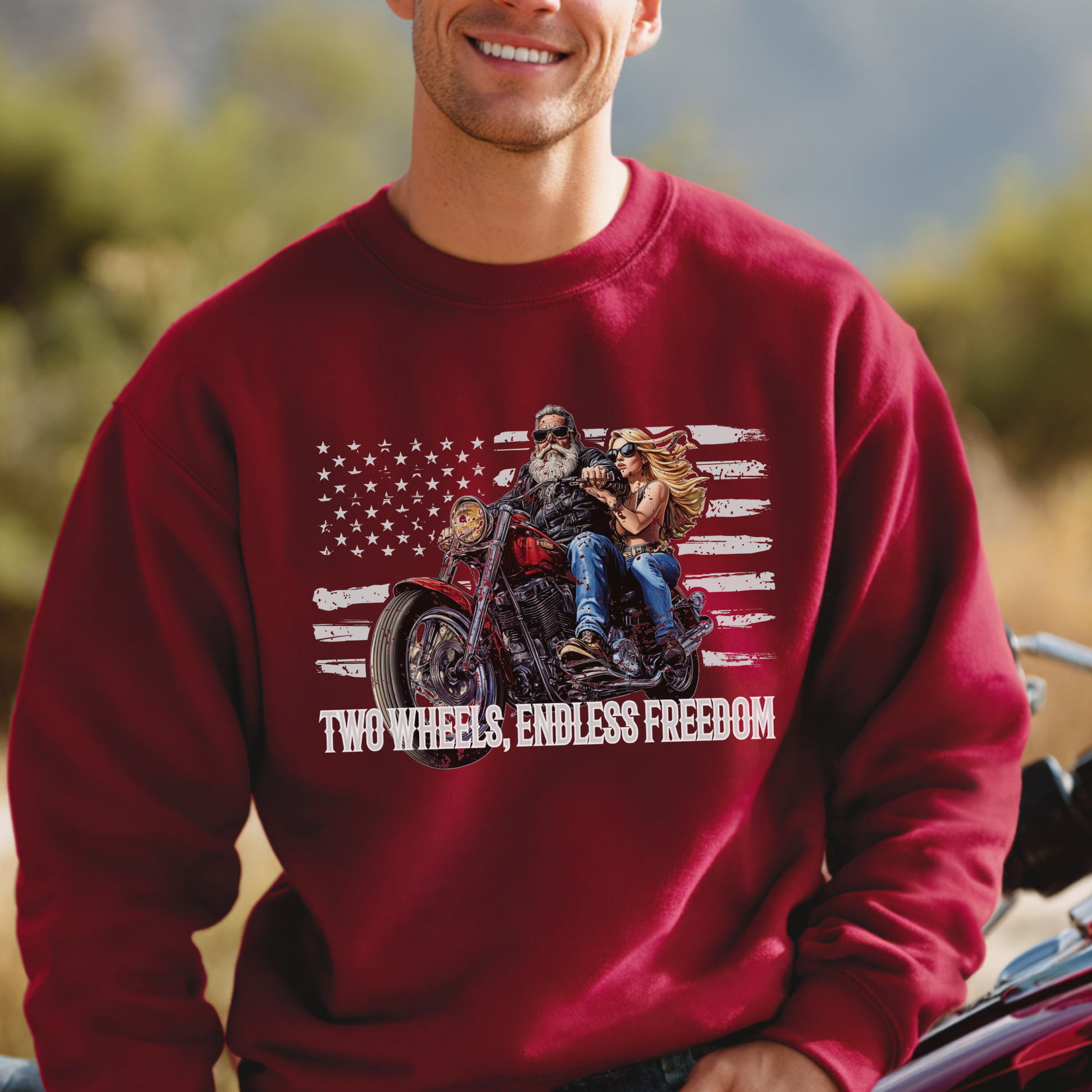 Person wearing a red sweatshirt with a graphic of people on a motorcycle and 'Two Wheels, Endless Freedom' text.
