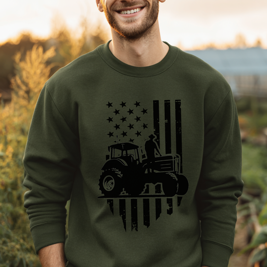 Man wearing a green sweatshirt with a tractor and flag design outdoors.