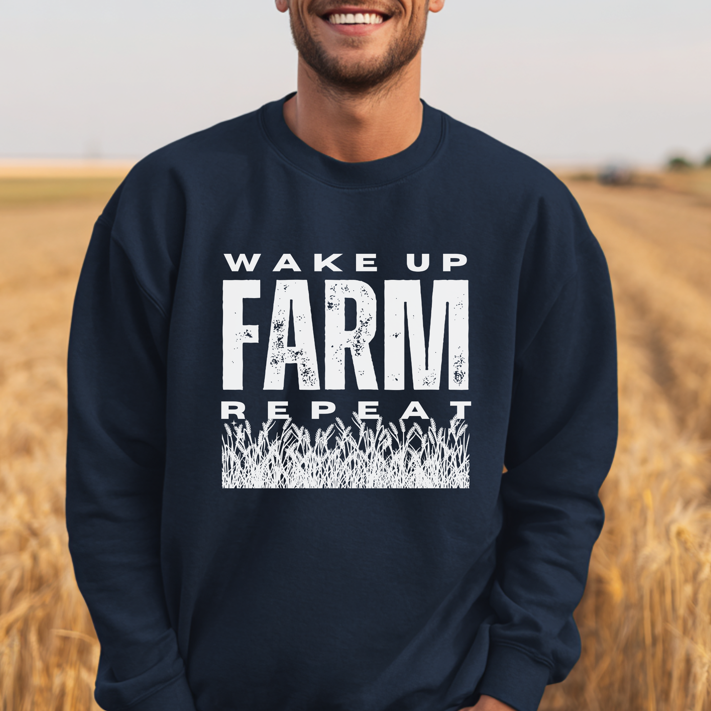 Person wearing a navy blue sweatshirt with 'Wake Up Farm Repeat' text in a field.