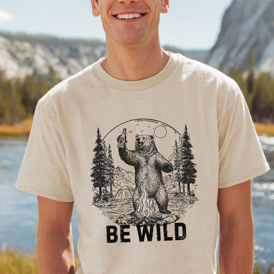 Man wearing a t-shirt with a bear graphic and 'Be Wild' text, standing outdoors.