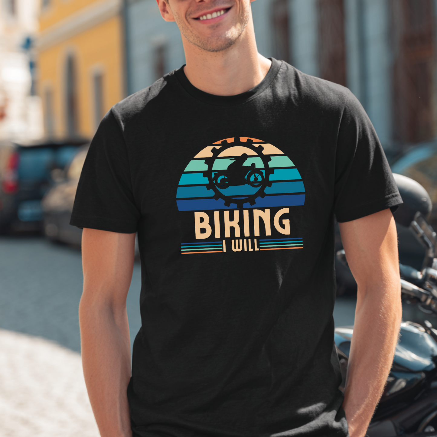 Person wearing a black t-shirt with 'Biking I Will' graphic design outdoors.