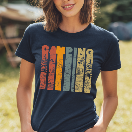 Person wearing a navy blue t-shirt with 'Camping' graphic in multicolor outdoors.