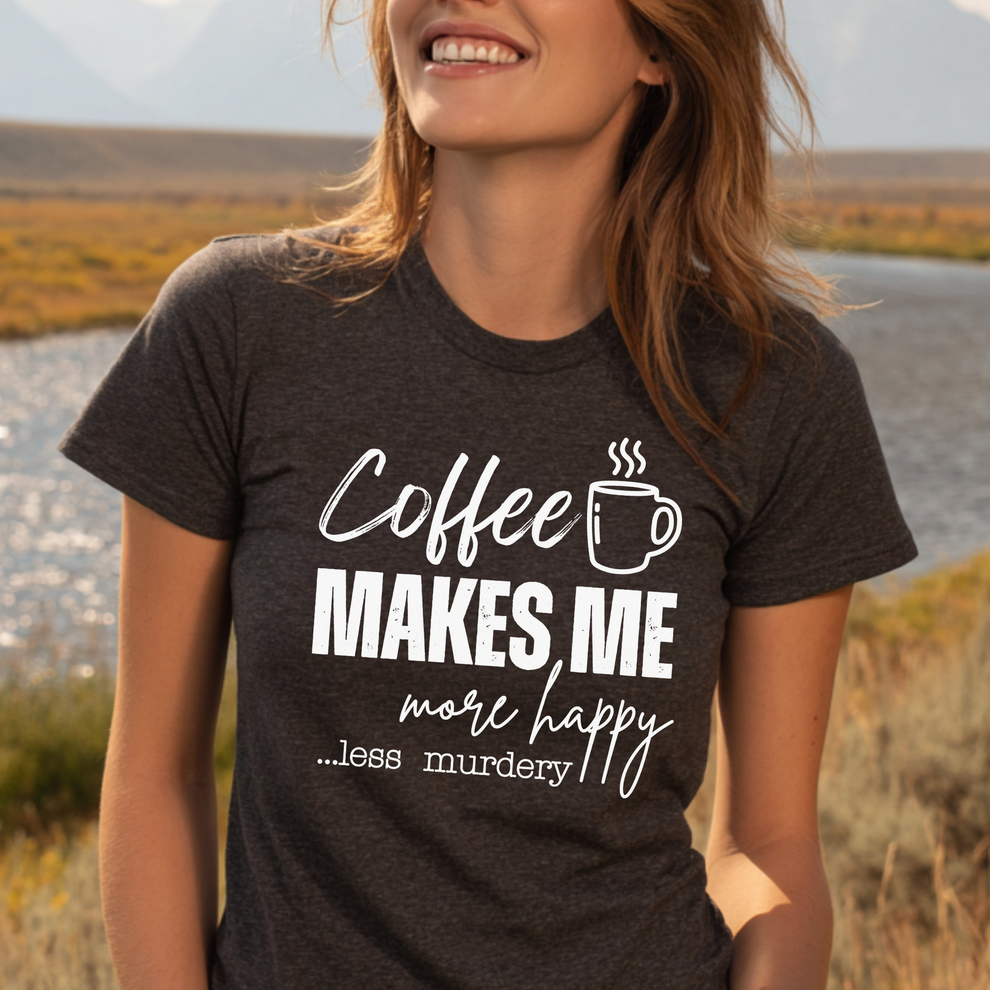 Person wearing a t-shirt with 'Coffee makes me more happy... less murdery' text and a coffee cup graphic, standing outdoors.