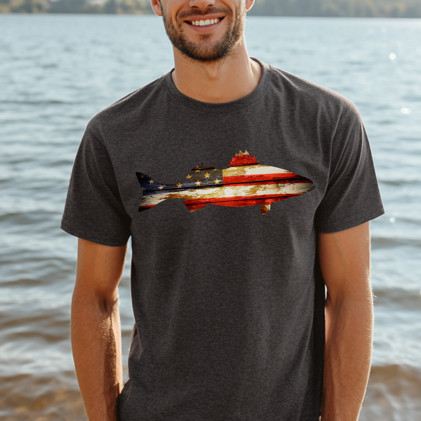 Man wearing a t-shirt with a fish design featuring the American flag by a body of water.