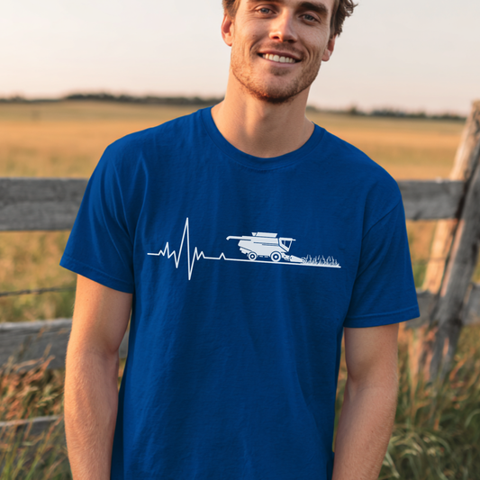 Man wearing a blue t-shirt with a white graphic design in a field