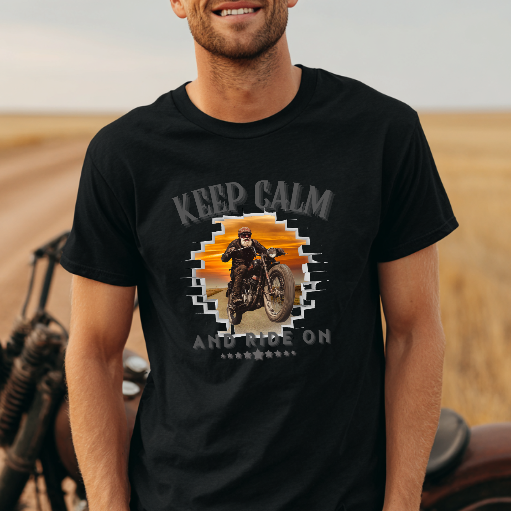 Man wearing a black t-shirt with a motorcycle graphic and 'Keep Calm and Ride On' text in a desert setting.