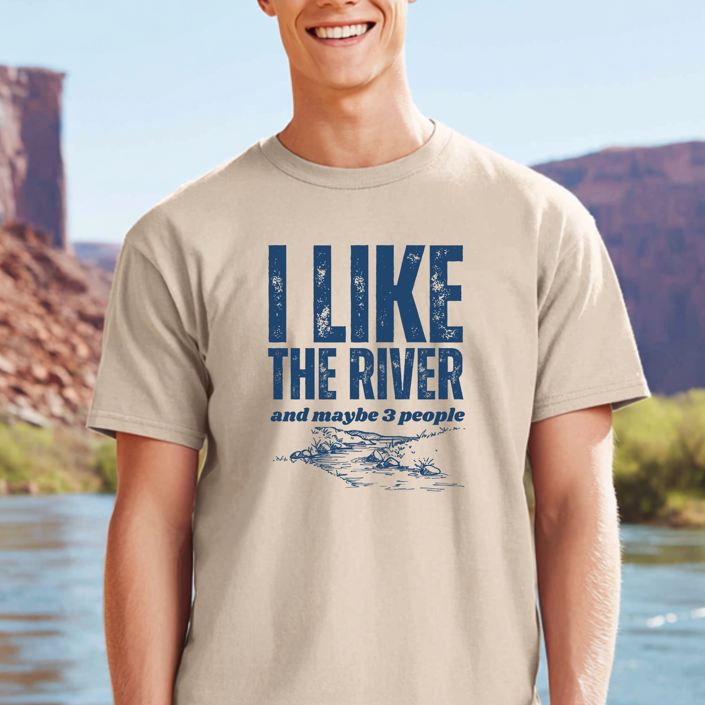 Person wearing a t-shirt with 'I Like the River and maybe 3 people' text by a river.