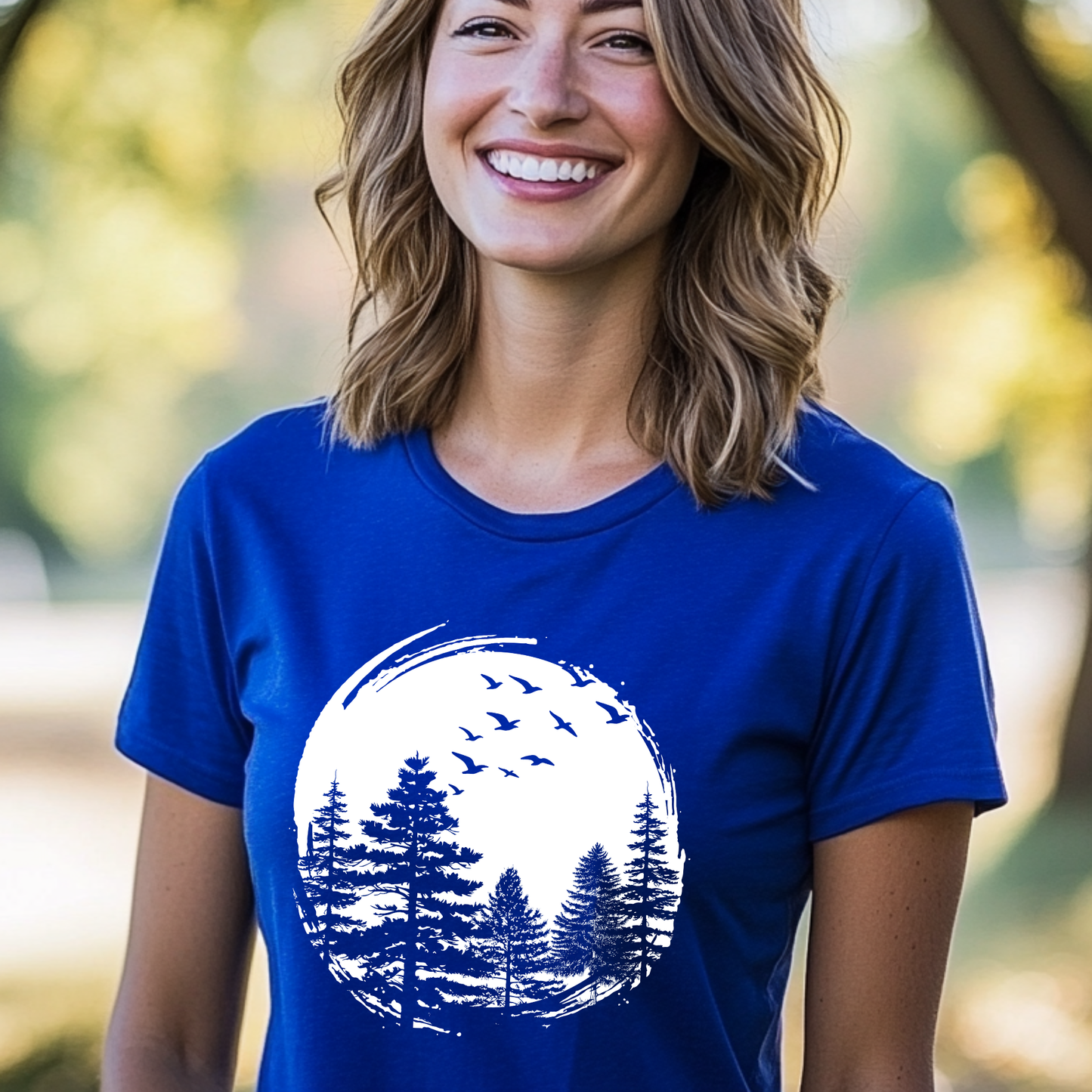 Woman wearing a blue t-shirt with a nature graphic outdoors