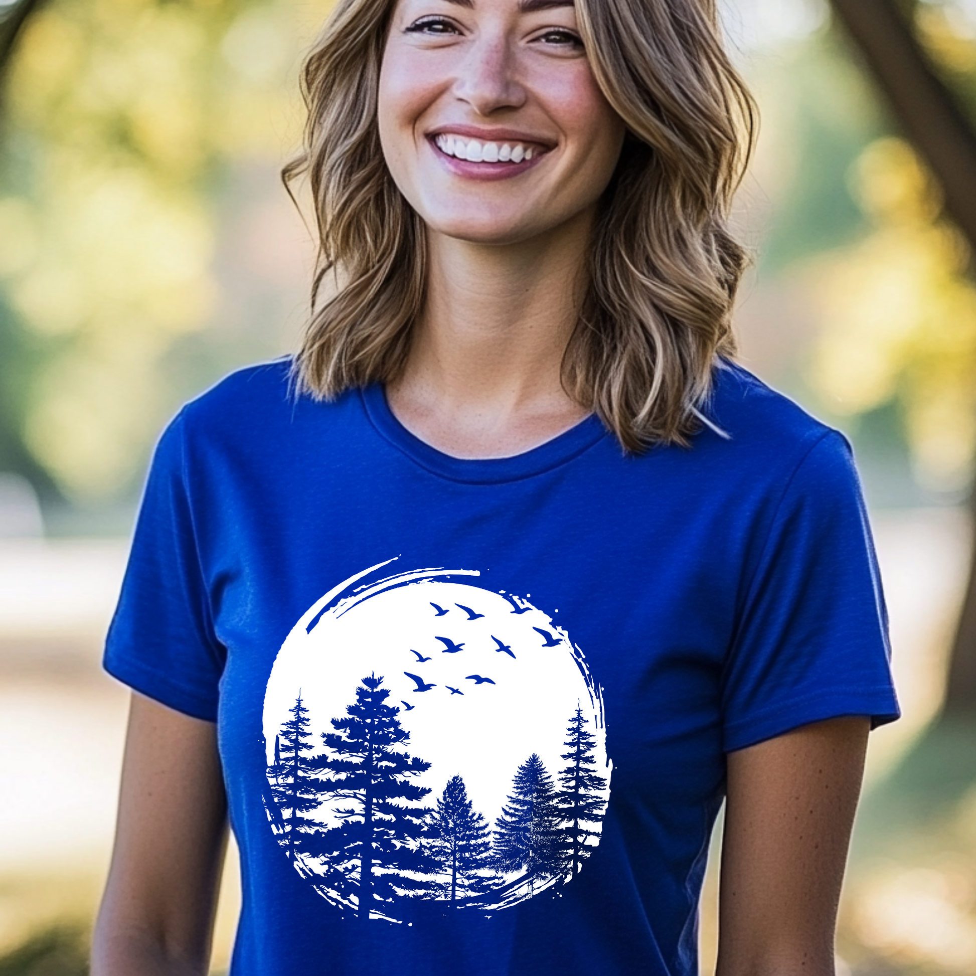 Woman wearing a blue t-shirt with a nature graphic outdoors