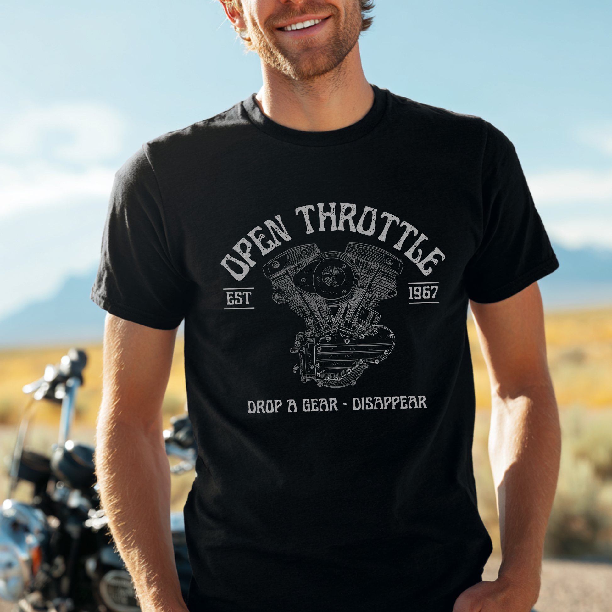 Man wearing a black t-shirt with 'Open Throttle' graphic design in a desert setting.